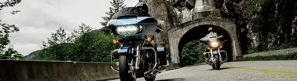 Two people riding Harley-Davidson® motorcycles through a tunnel on the back-roads.